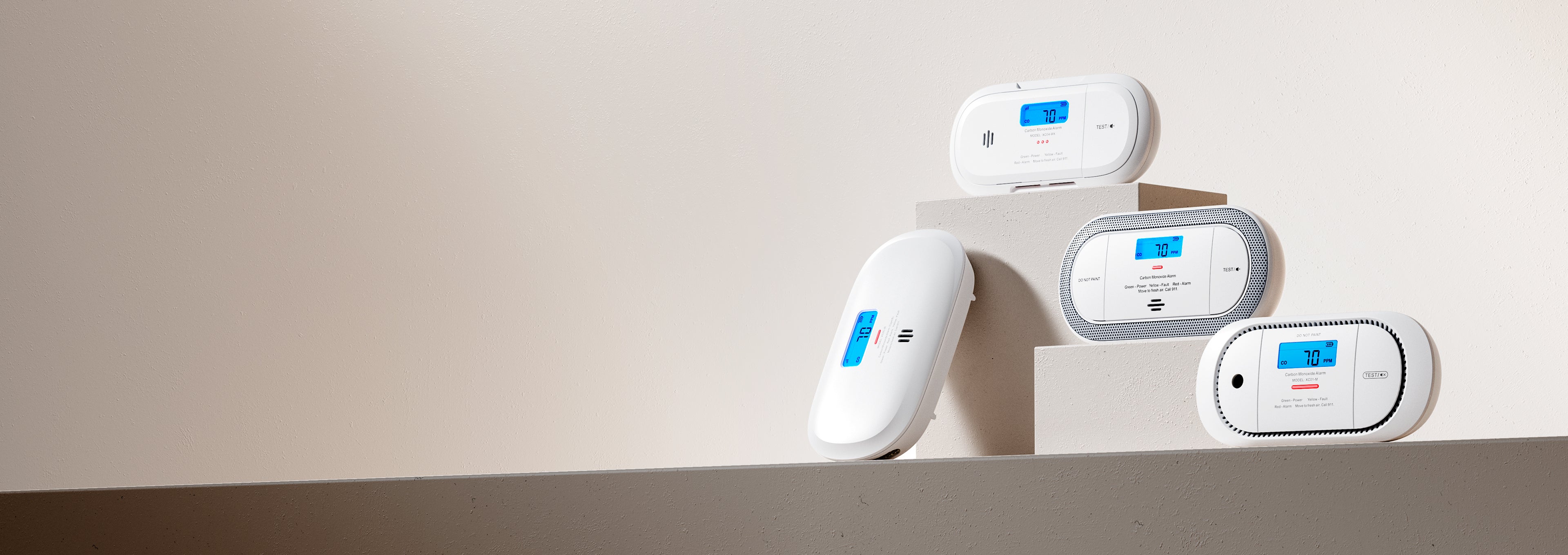 Four white electronic devices with blue and red indicators on a beige background