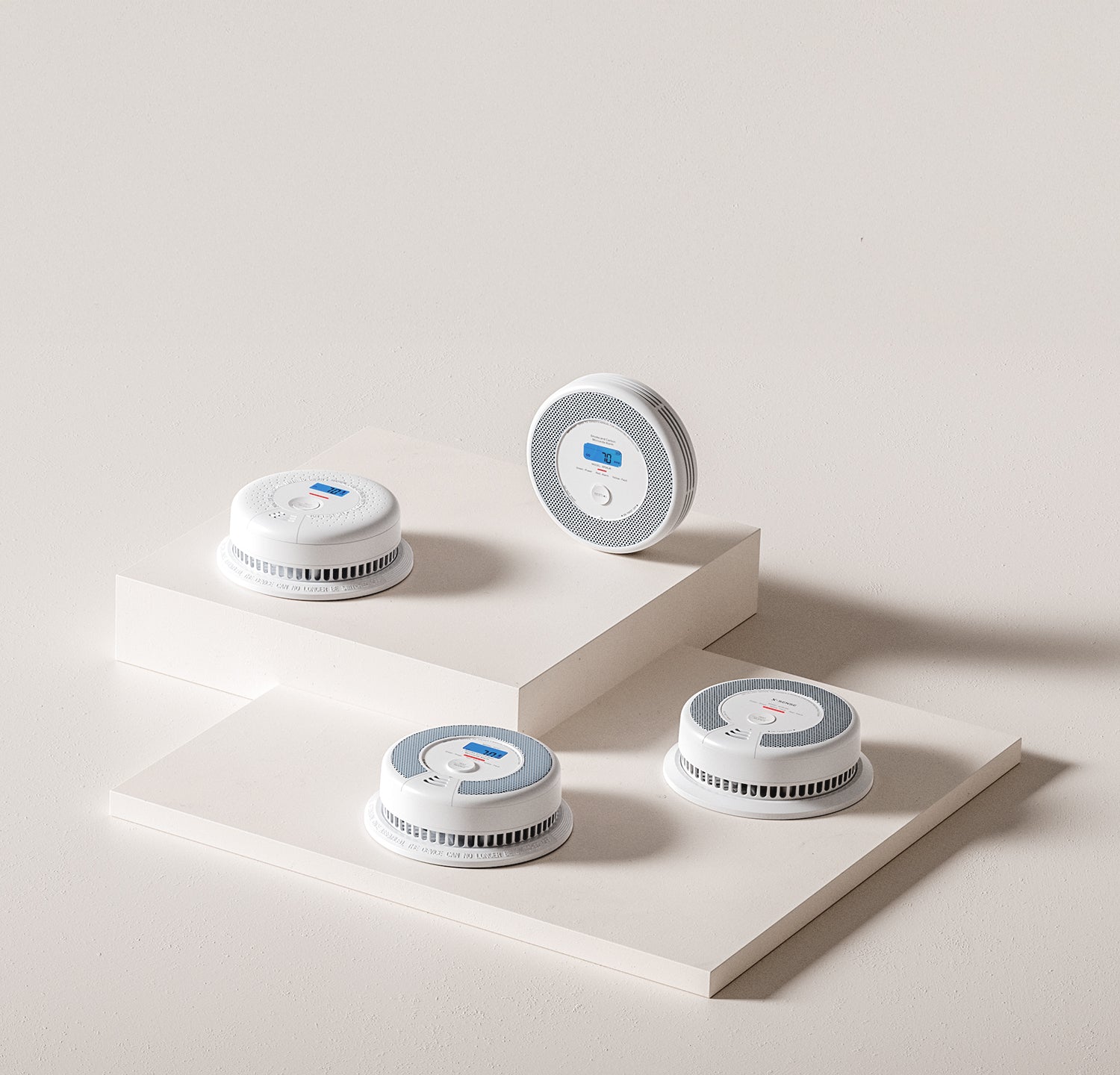 Four round white devices with blue accents on a light gray surface