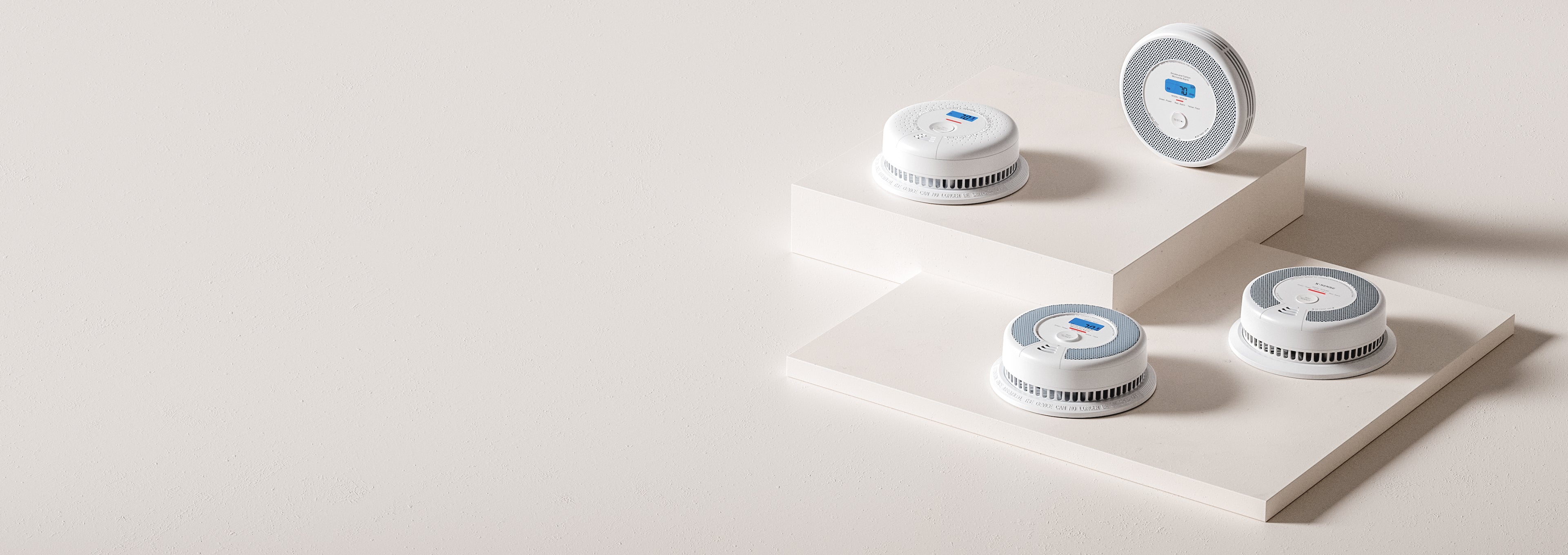 Three white electronic devices with circular designs on a light gray background