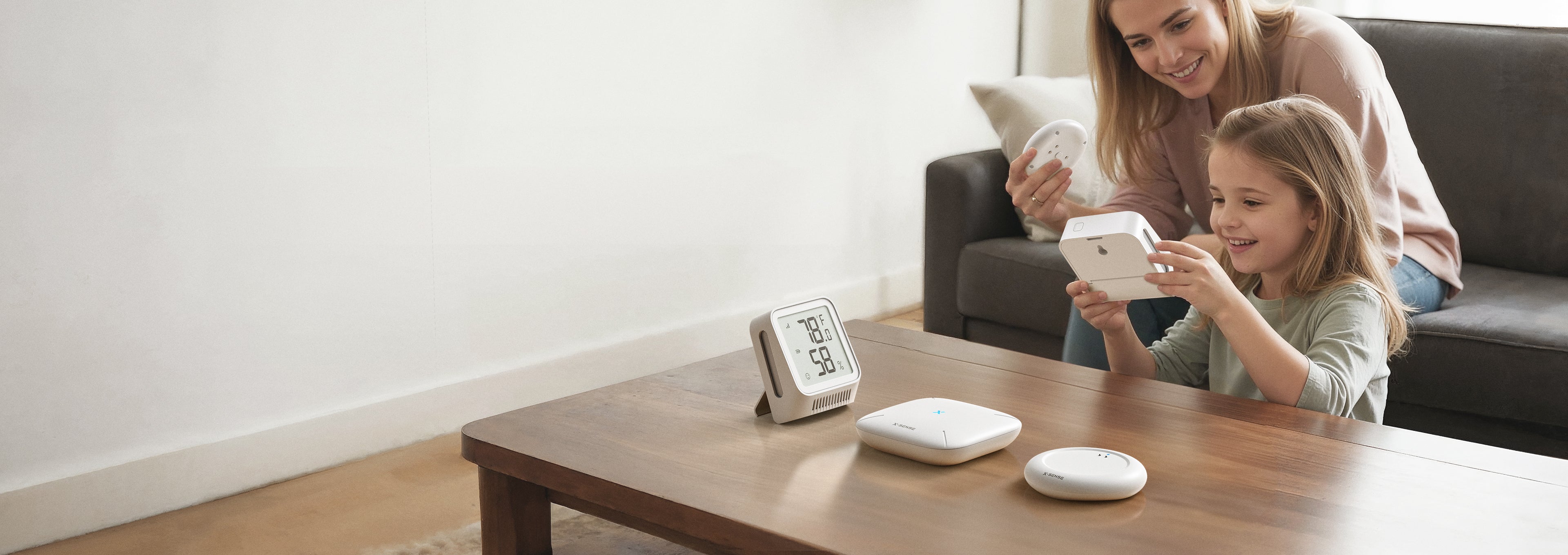 Woman and child using a smartphone with a smart home device on a table