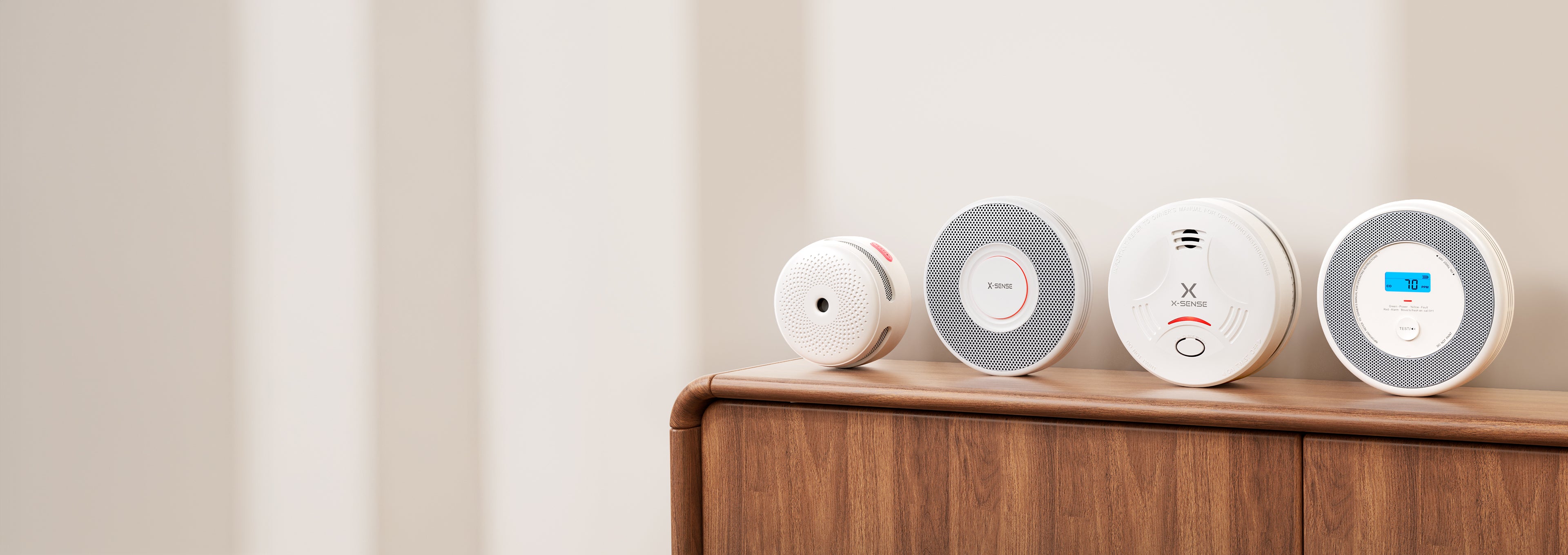 Four round devices on a wooden surface with a neutral background